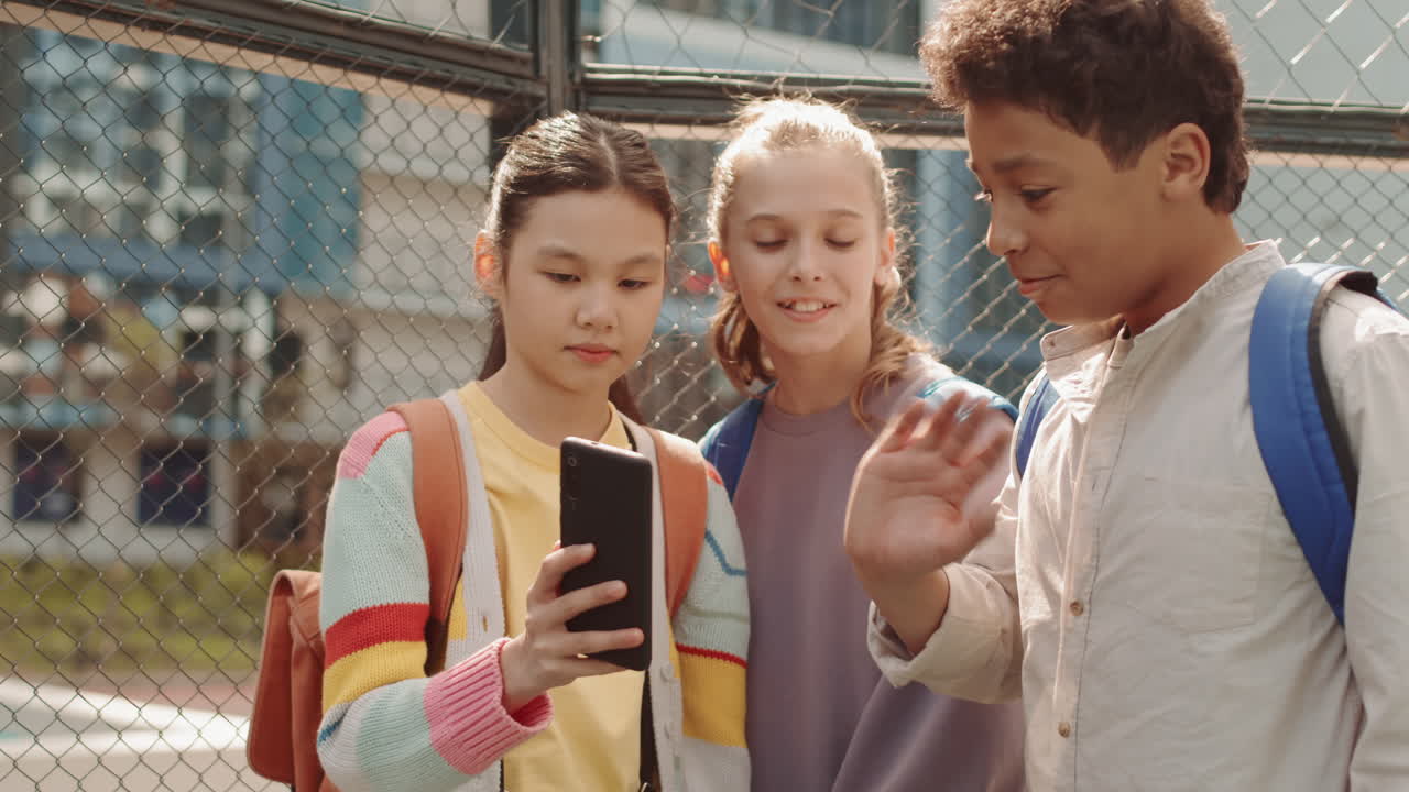School Children Video Chatting on Smartphone Outdoors