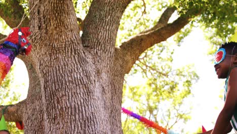 Niño-Golpeando-Un-Títere-Multicolor-Con-Un-Palo