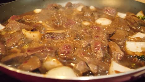 beef and broccoli cooking in a skillet