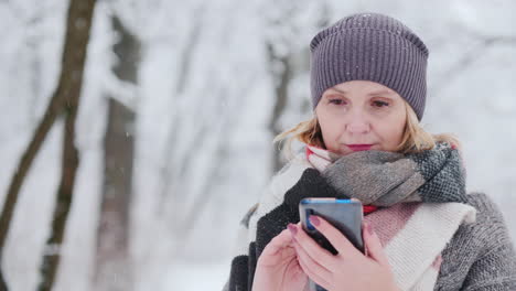 年轻女子在雪地公园使用智能手机