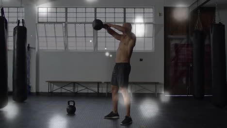 man exercising with kettlebell in gym over glowing particles animation