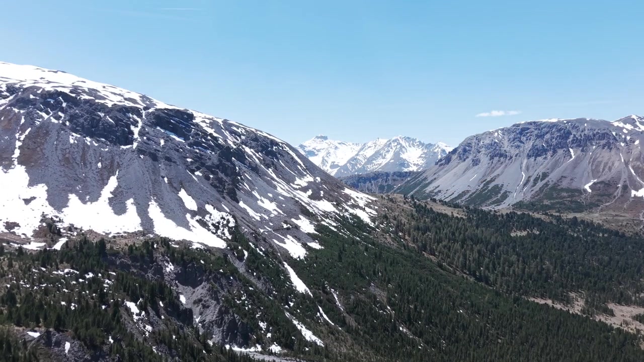 La telecamera vola lungo le guglie rocciose frastagliate di Jalet verso una valle innevata delle Alpi dell'Ortles e una foresta di conifere in una giornata limpida.