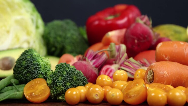Variety of fresh colored vegetables and fruits on wooden table