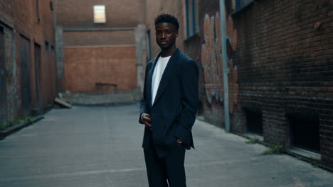 stylish young man in a suit standing in an urban alleyway