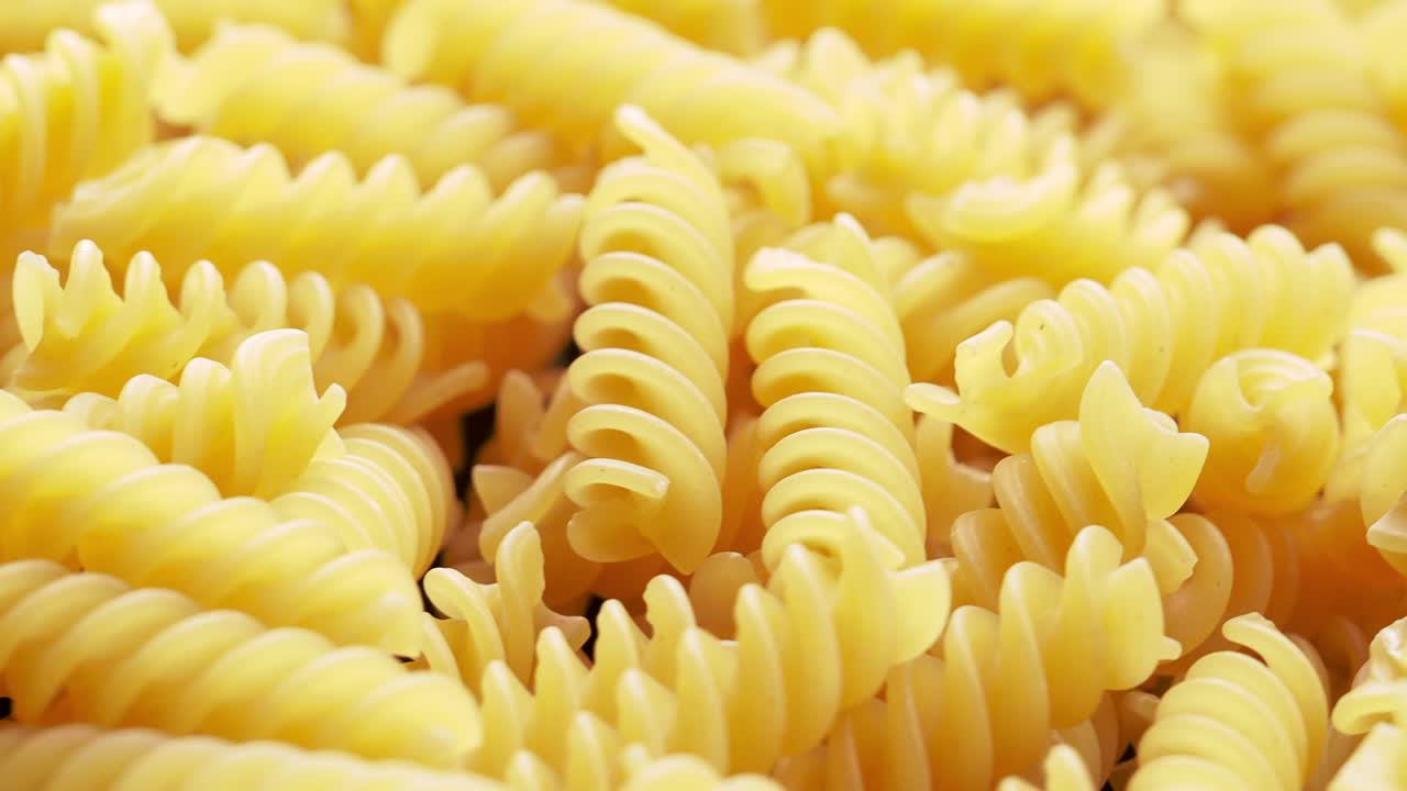 un primer plano de la pasta italiana de fusilli en bruto girando en círculo