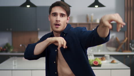 retrato de un joven bailando en la cocina de su casa. un chico sexy divirtiéndose en el interior.