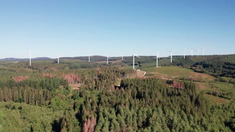 aerial shot of a wind turbine farm in southern france surrounded by green forests