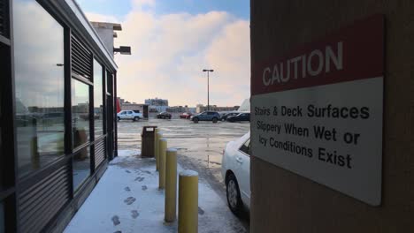 City-Parking-Garage-Roof-In-The-Snow-With-Caution-Warning-Sign