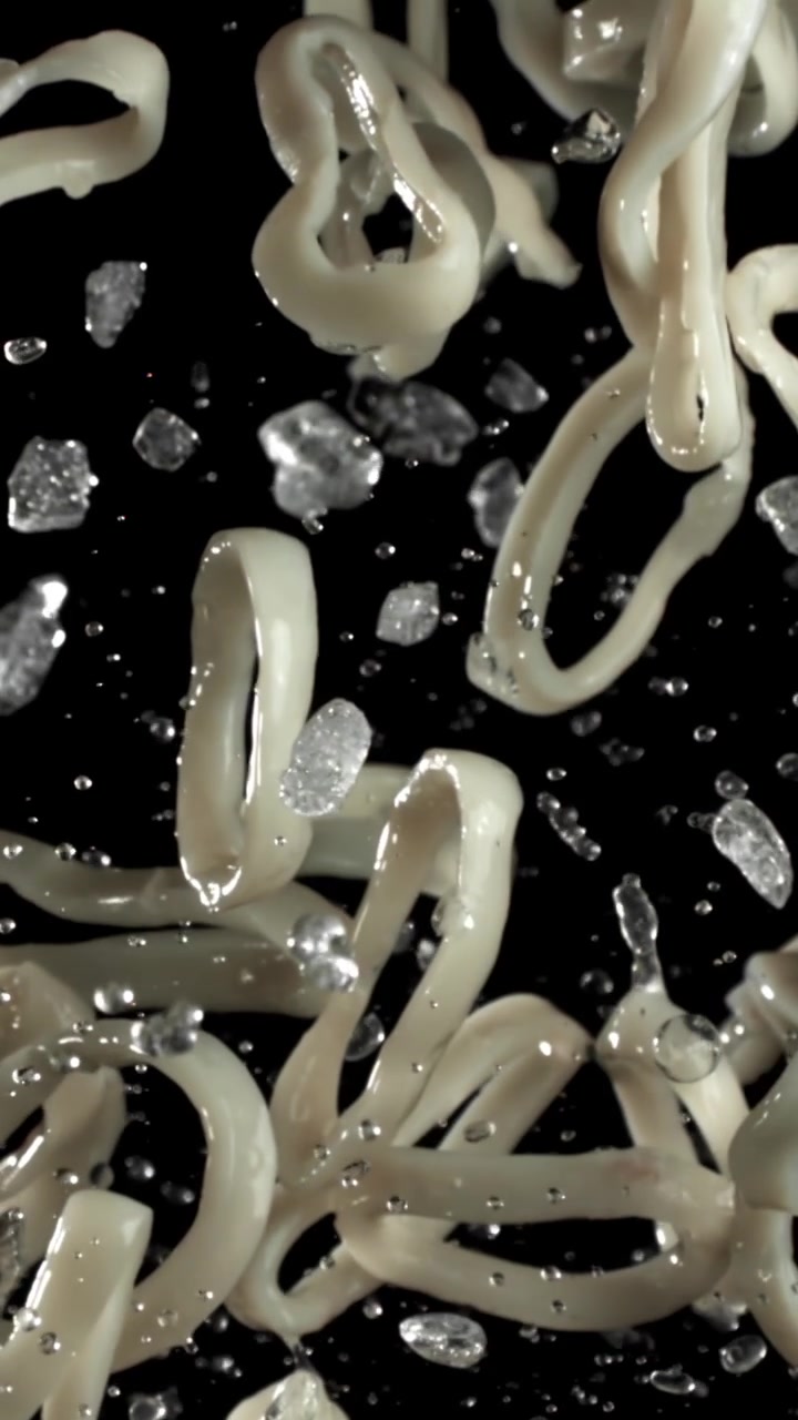 Anelli di calamari freschi e cubetti di ghiaccio che cadono al rallentatore