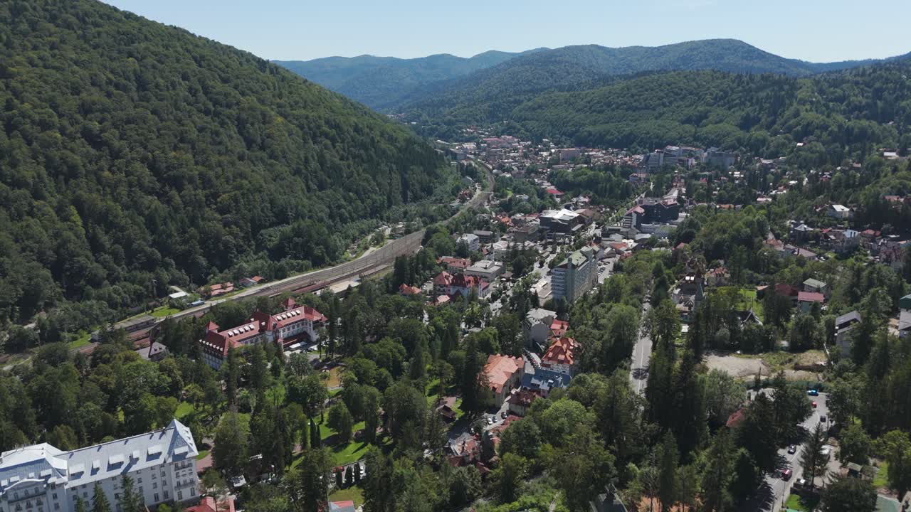 Drone flying over the Holy Trinity Church and moving toward the town of Sinaia, showcasing architecture and urban scenery