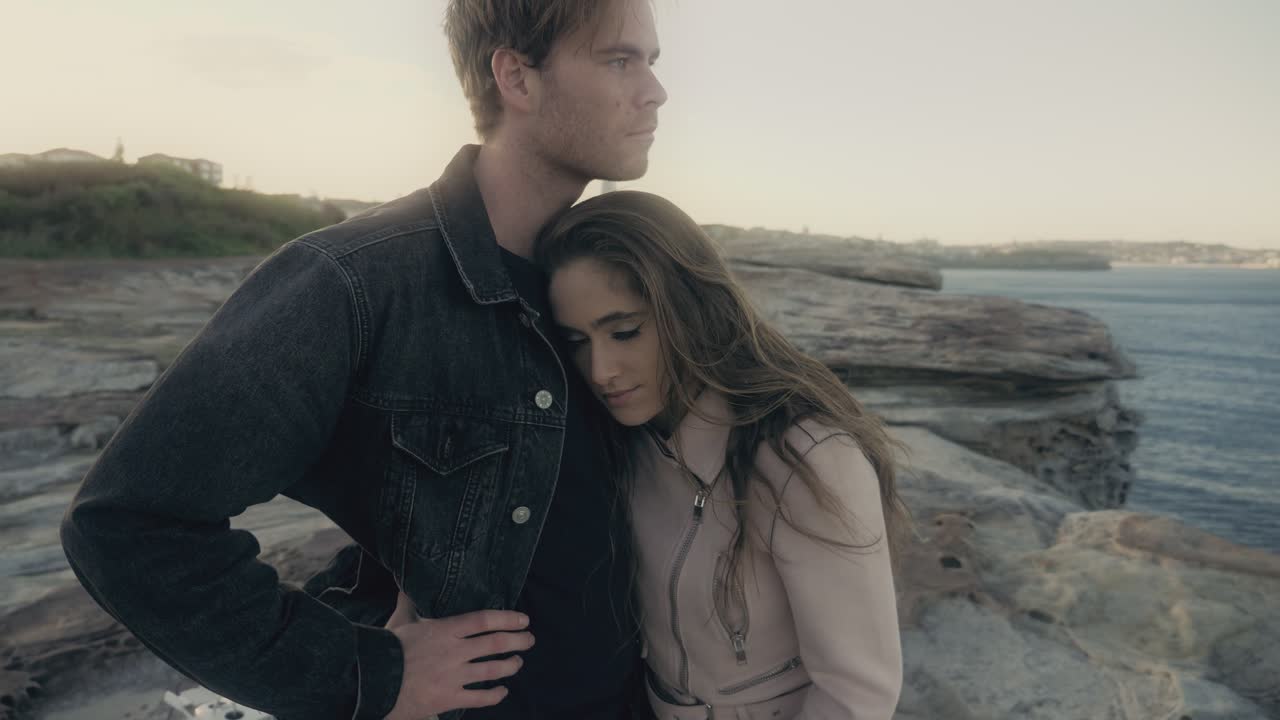 영국 클로벨리의 바위 절벽에서 남자의 가에 머리를 기대고 그의 따뜻함을 느끼는 여자 - 클로벨리