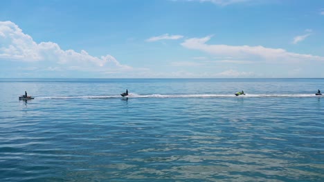 Antenne-Von-Vier-Touristischen-Jet-Skis,-Die-An-Sonnigen-Sommertagen-Im-Blauen-Tropischen-Wasser-Fahren