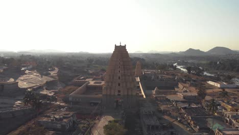 Vista-Superior-Del-Templo-Virupaksha-En-Medio-De-Cerca-De-Las-Orillas-Del-Río-Tungabhadra-En-Hampi,-India---Punto-De-Interés-De-La-órbita-Aérea-Tiro