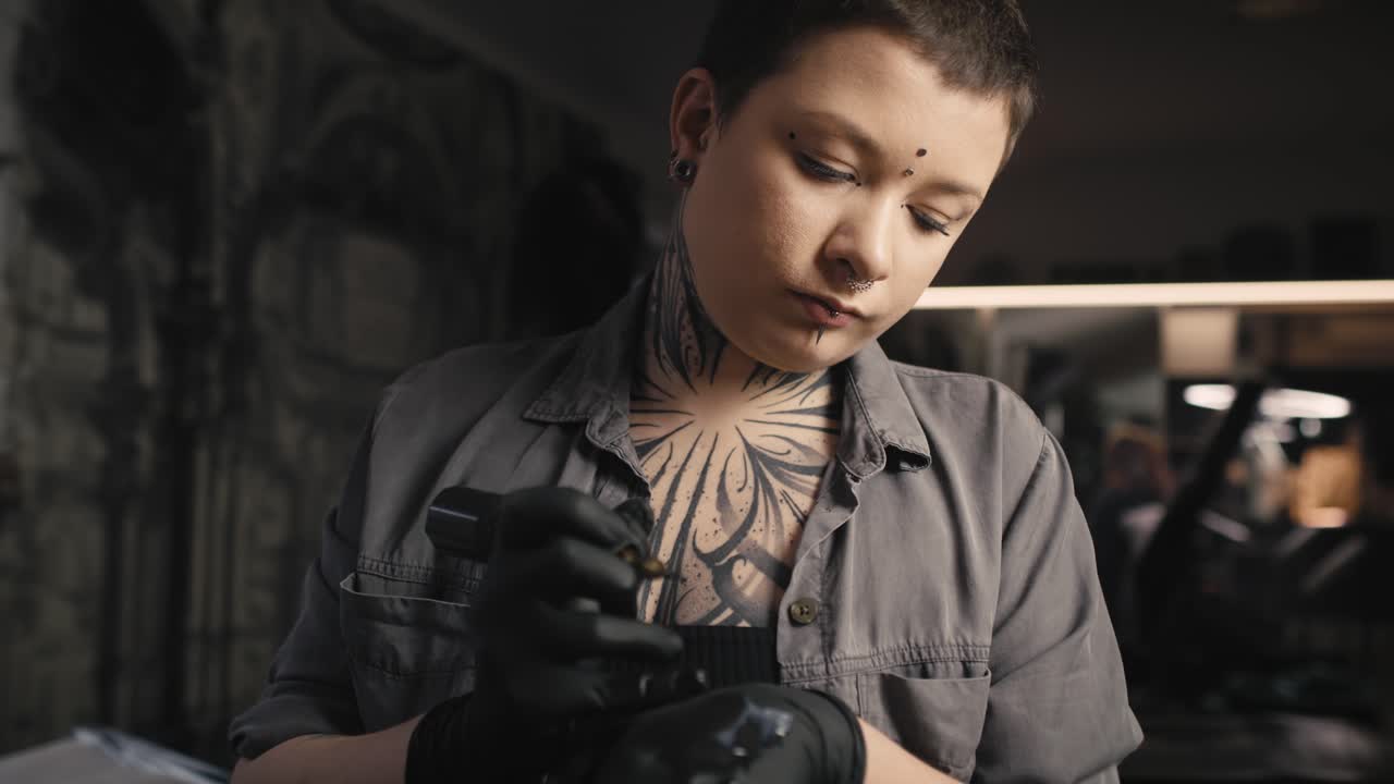 Donna caucasica concentrata che tatua le braccia del suo cliente.