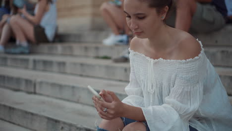 joven usando un teléfono inteligente en las escaleras de la ciudad