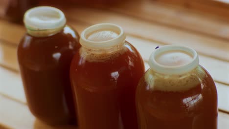 three bottles full of apple juice on a wooden floor