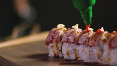 cook decorating sushi set with spicy red sauce