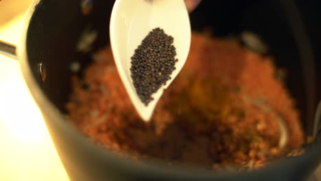 Extreme-Close-Up-of-Female-Hands-Adding-Mustard-Seeds-to-Lentils-