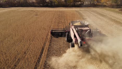 Harvesting-Soybeans-On-The-Field-With-Combine-Harvester-Creating-Dust-And-Smoke-In-Monroe-County,-Michigan,-USA