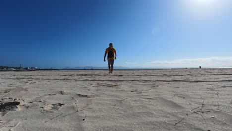 hombre llegando a la playa y desnudándose para bañarse