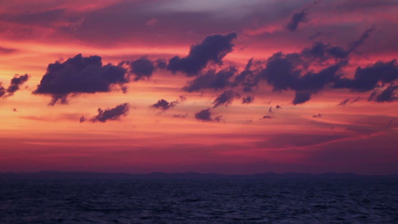 Dramatic and cinematic colors fill the sky over the Andaman Sea at sunrise