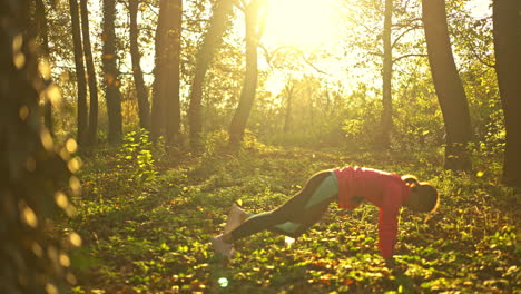 woman exercising and stretching in a sunny autumn forest