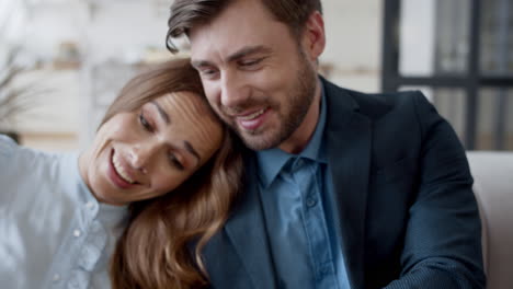 retrato de un hombre y una mujer mirando la pantalla de una computadora portátil en el sofá. una pareja viendo una película