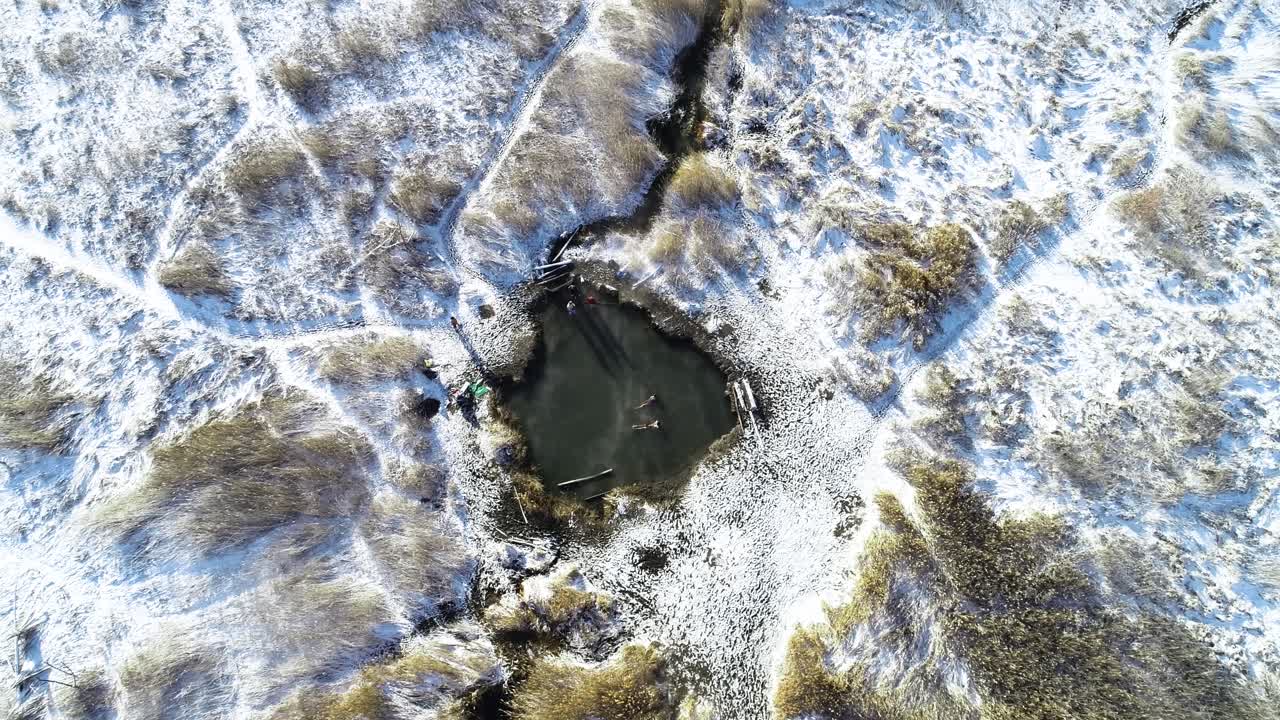 varios nadadores tirados en las aguas termales de saratoga en provo utah durante la puesta de sol y el vapor saliendo del agua con nieve en el suelo