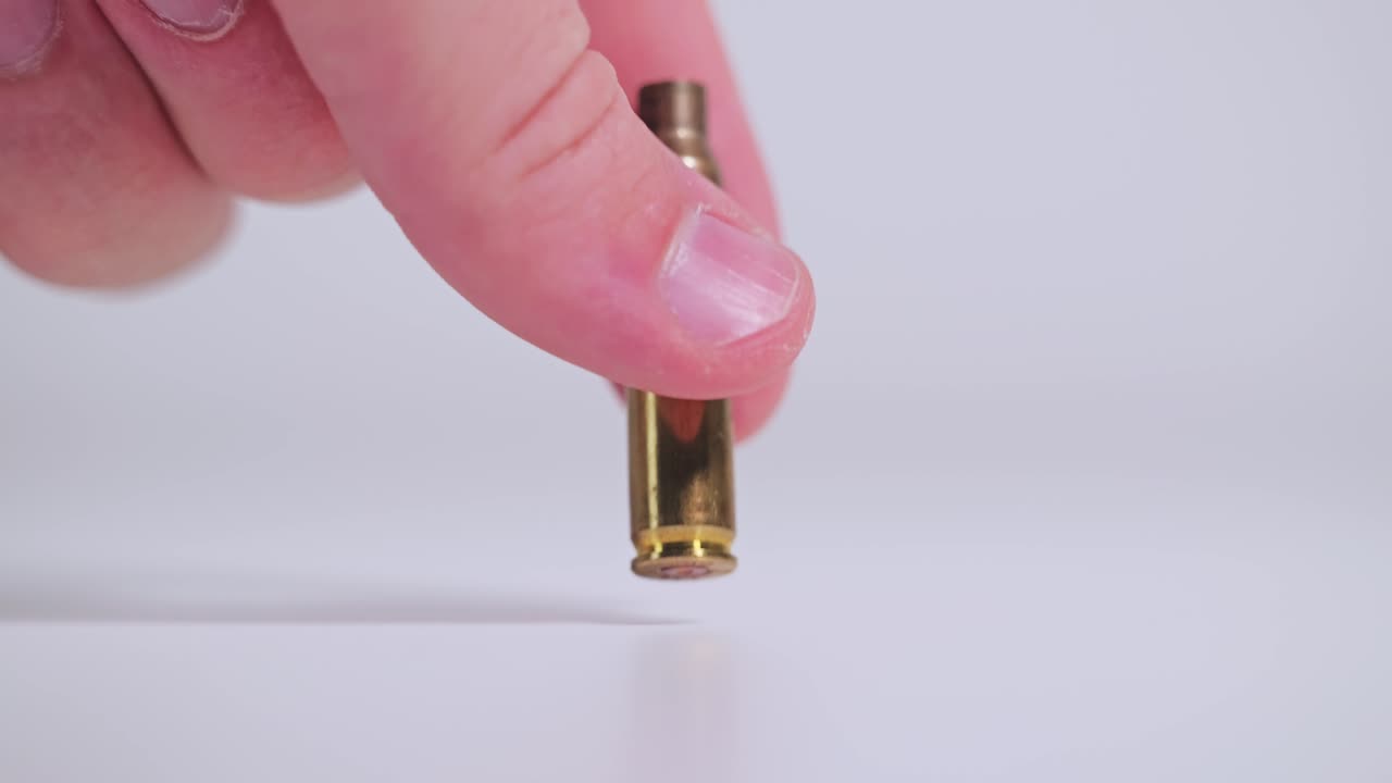 Hand picking up empty bullet casing symbolizing recovery after war ends