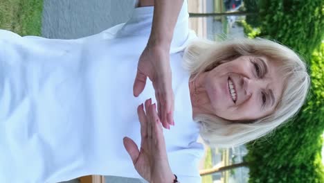 smiling elderly woman in white shirt outdoors