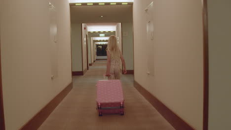 child walking through hotel corridor with luggage