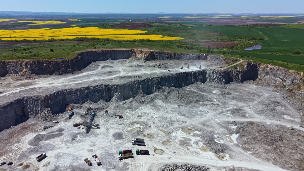 Large mining area under operation with vehicles and machinery working on site in an open pit location during bright daylight