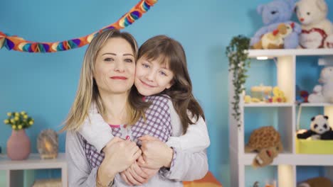 cute little girl and her mother smiling at the camera. love of mother.