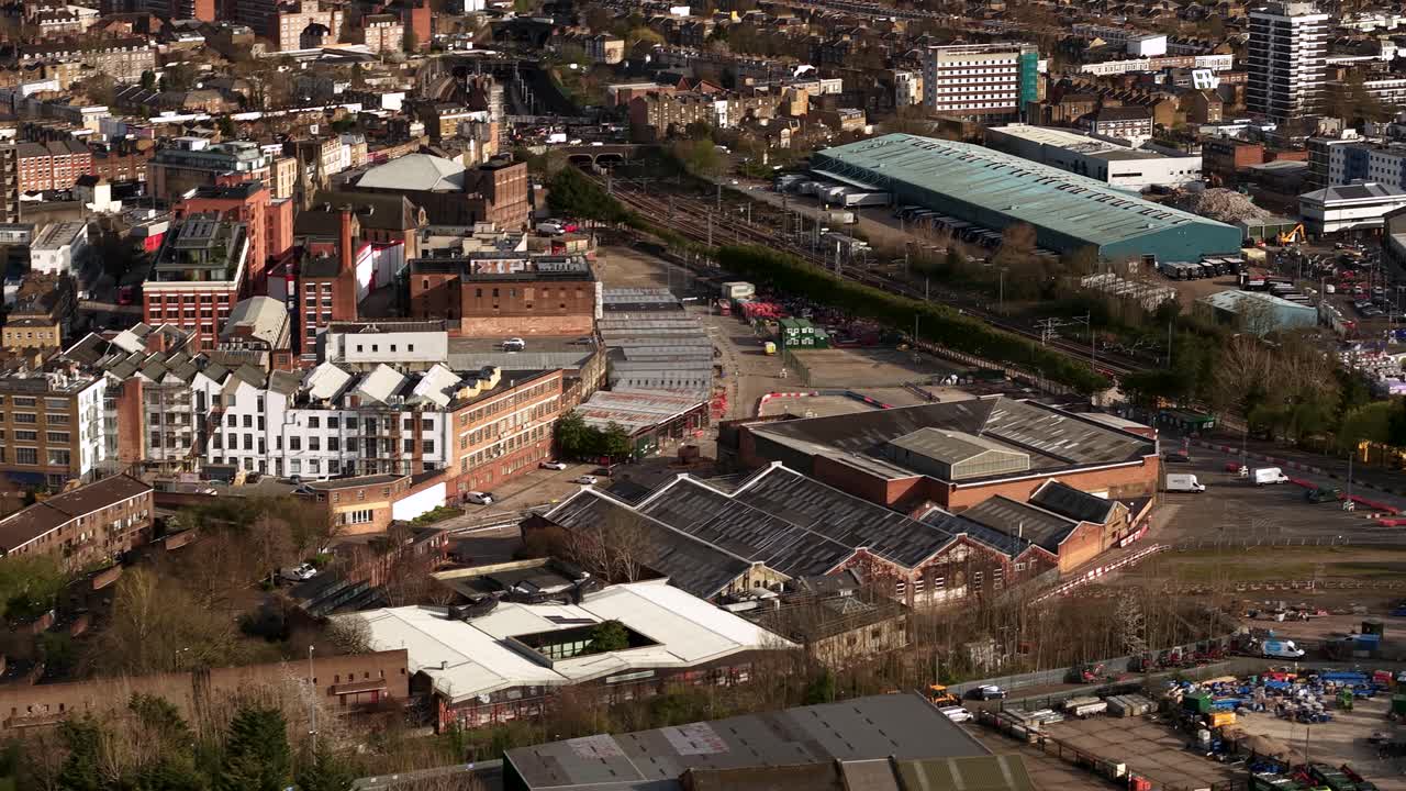 Industrial warehouse downtown aerial view tilt up to reveal vast London city landscape and skyline