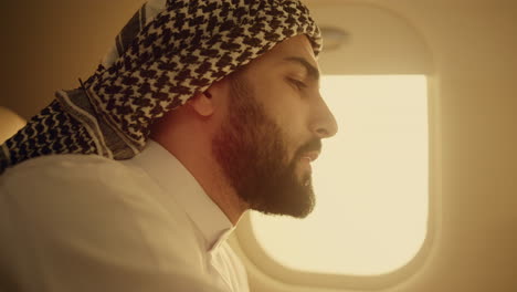 successful businessman traveling airplane closeup. happy arabic man resting