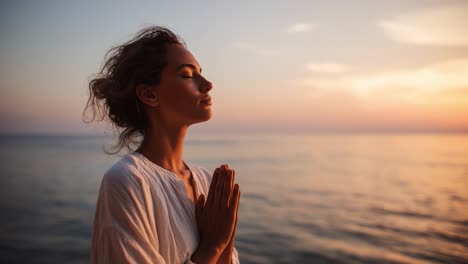 woman practicing yoga at sunset on beach