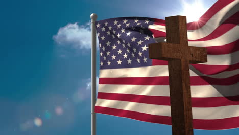 waving american flag beside wooden cross under bright sun and blue sky