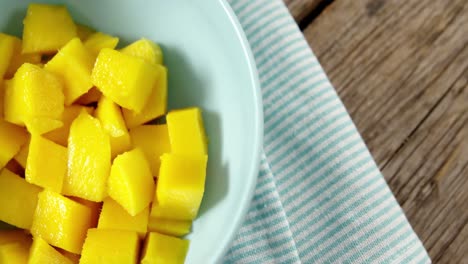 mangos picados en un tazón en una mesa de madera