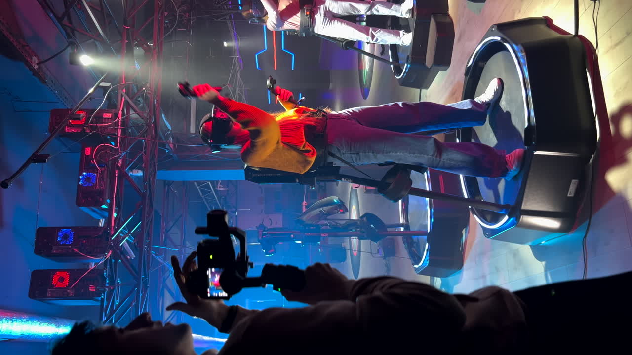 Camera man filming a girl playing with a Virtual Reality headset in a studio. Vertical