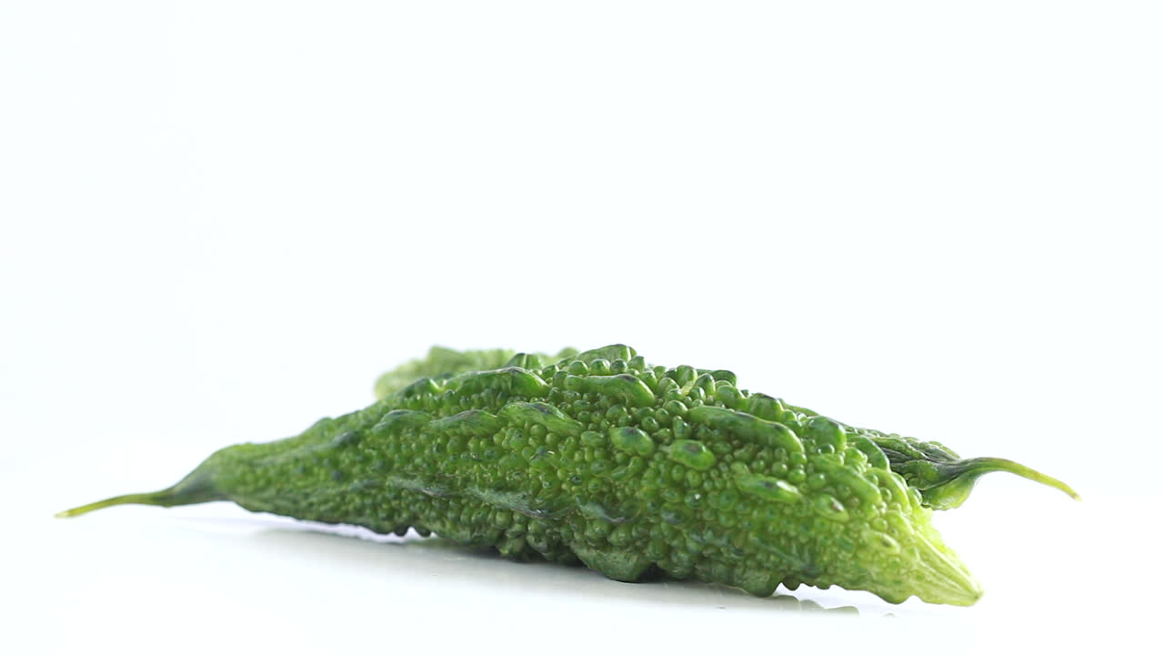 흰색 배경 측면 샷에서 360도 회전하는 두 개의 여주 쓴 멜론 야채