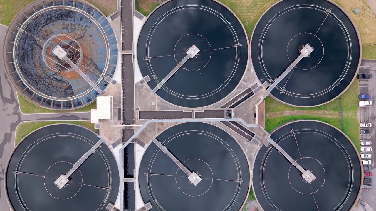 Aerial birds eye view of circular basins at a wastewater treatment facility. Rising Shot