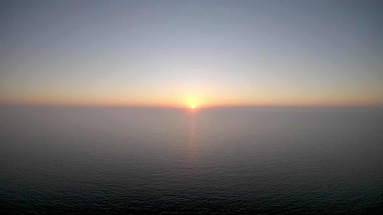 imágenes aéreas 4k de drones del sol justo antes de que se ponga sobre el mar en calm beach, en nápoles, florida, ee.uu.