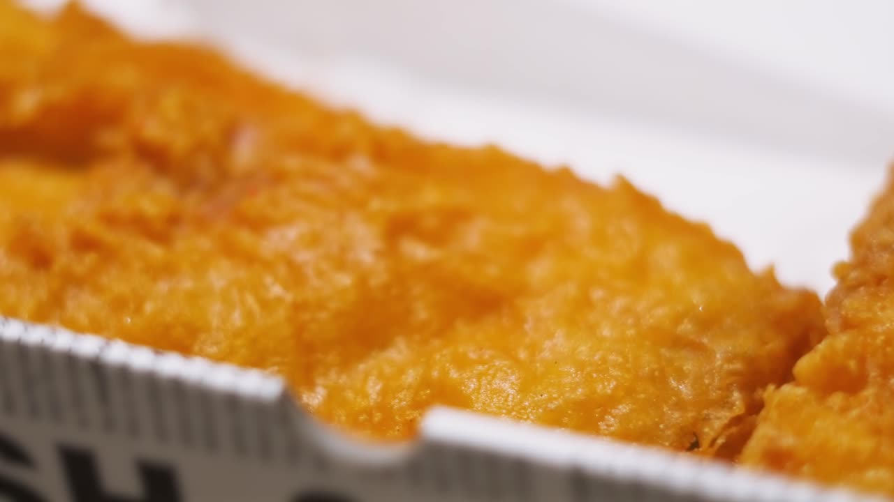 Side View of Crispy Delicious Battered Fish in Takeaway Box Ready to Eat. Delicious Fresh Cod Seafood Dinner Served in Britain