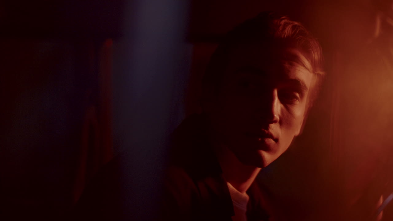 Young Man Waking Up in Car Driver Seat at Night, Gazing around in Surprise