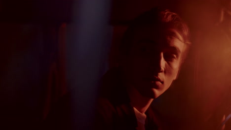 young man waking up in car driver seat at night, gazing around in surprise