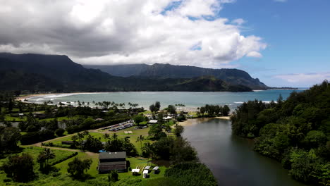 Pase-Aéreo-Sobre-El-Río-Hanalei-Hacia-La-Bahía-De-Hanalei-Con-Algunas-Nubes