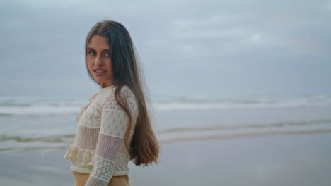 mujer sensual mirando cámara costa del mar de cerca. dama observando la naturaleza verticalmente