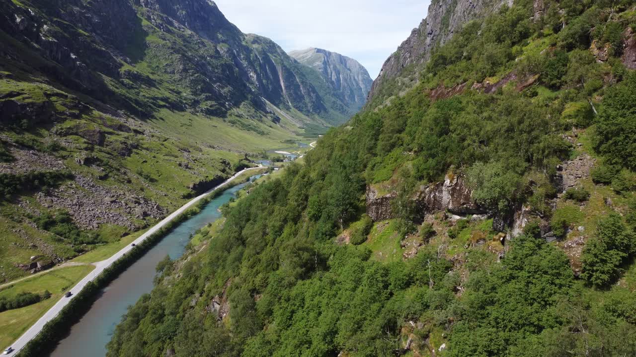 los turistas viajan a través del valle de la montaña para llegar al norte de noruega - antena stardalen e-39 noruega - vista desde la ladera de la montaña