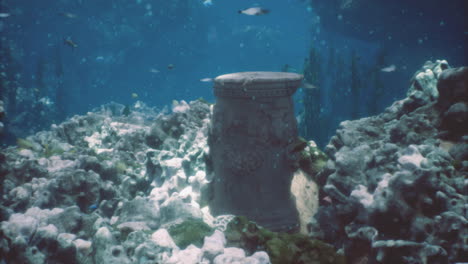 ruinas de una antigua columna de piedra sumergida en aguas azules claras