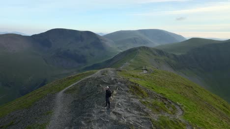 Mountain-walker-on-summit-of-high-English-peak-with-long-orbit-showing-Lakeland-peaks-and-valleys-prior-to-sunset